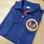 Polo marinho com detalhes laranja. Polo